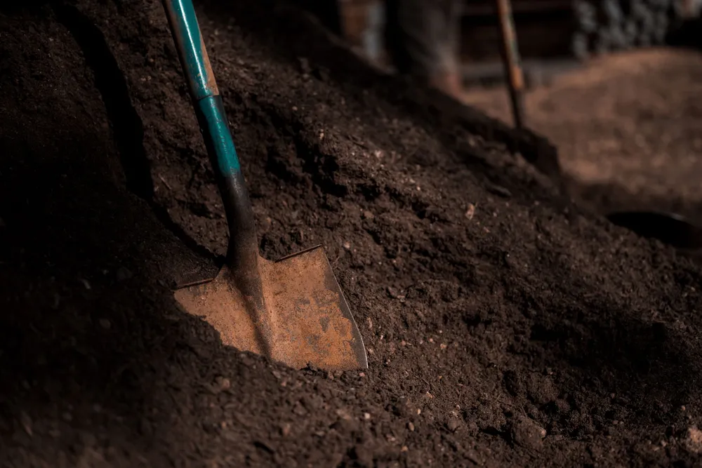 Shovel turning a pile of dark, rich compost mix at Riverside Wood in Norman, Oklahoma