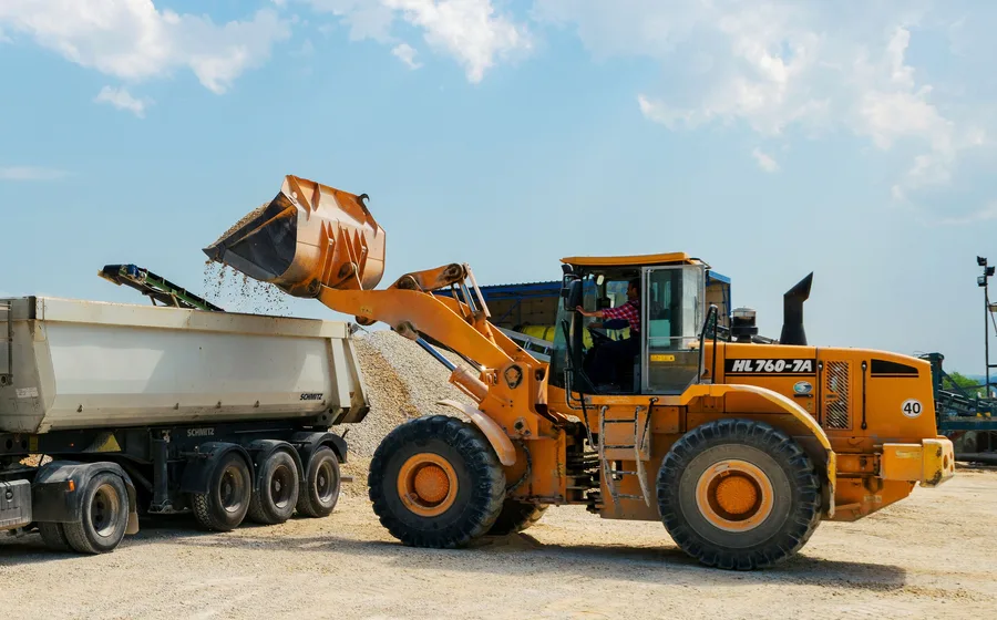 Semi dump trailer being loaded with bulk material for large freight delivery near Norman, OK